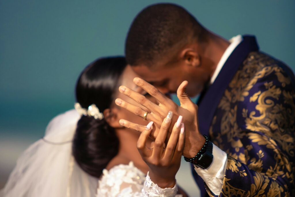 young african couple giving their first kiss on their wedding day